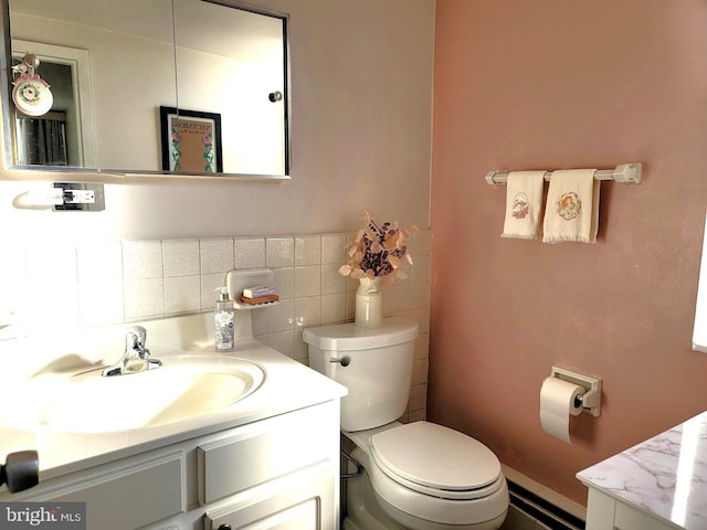 half bathroom with toilet, tile walls, and vanity