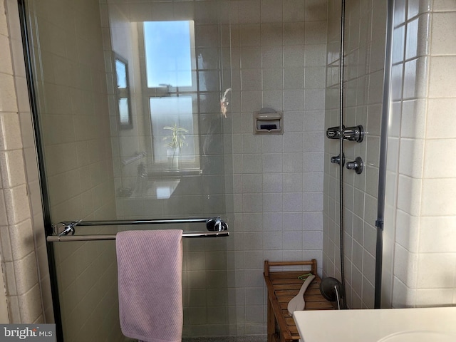 bathroom featuring a shower stall, tile walls, and vanity