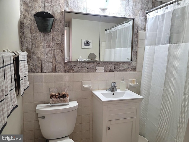 full bath featuring tile walls, vanity, and toilet