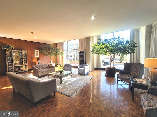 living room with wooden walls and floor to ceiling windows