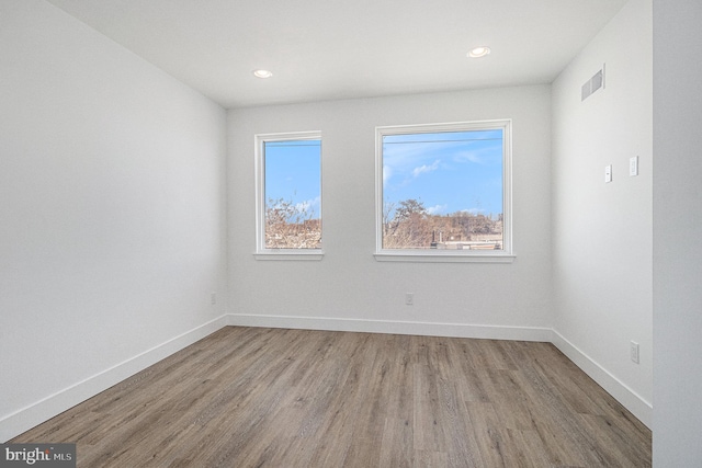 spare room with visible vents, recessed lighting, wood finished floors, and baseboards