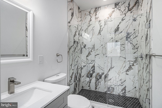 full bathroom with a marble finish shower, toilet, and vanity