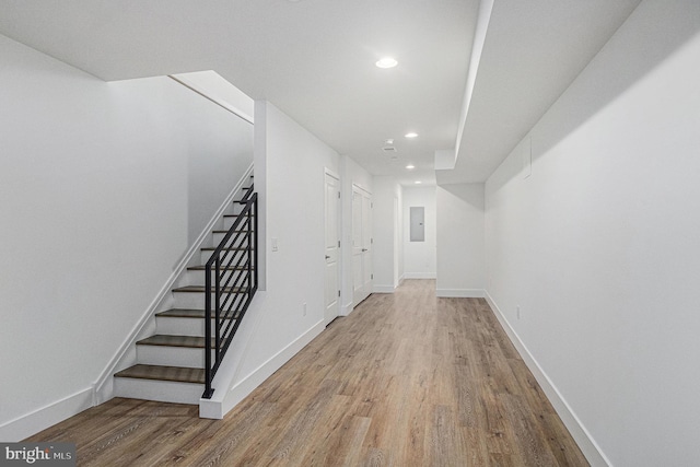 interior space featuring stairs, electric panel, wood finished floors, and baseboards