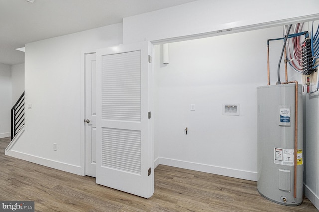 washroom featuring electric water heater, baseboards, washer hookup, laundry area, and wood finished floors