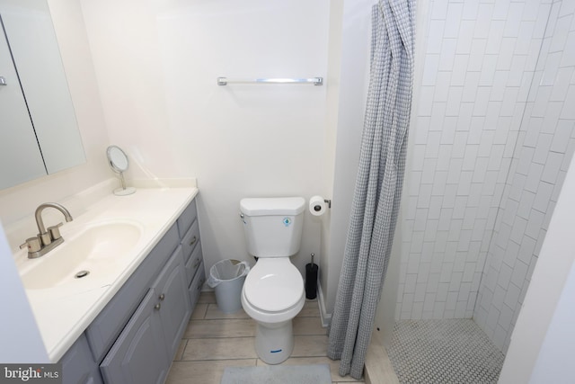 bathroom featuring a shower stall, vanity, toilet, and tile patterned floors