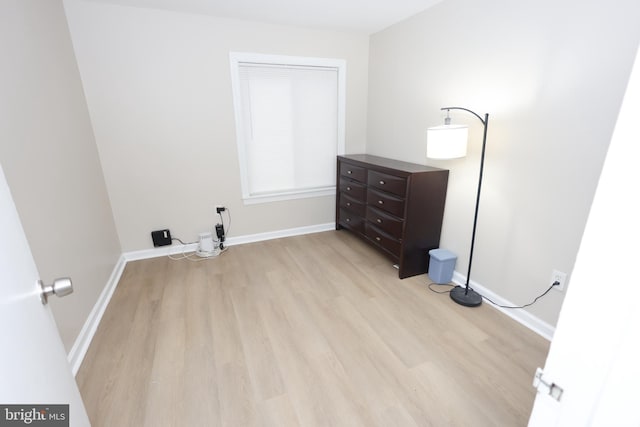 laundry room featuring baseboards and light wood finished floors