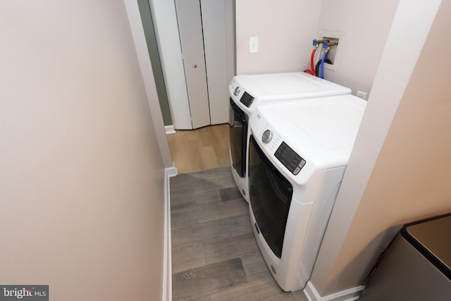 washroom featuring laundry area, wood finished floors, and washer and dryer