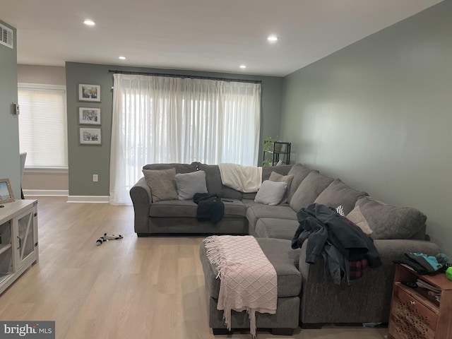 living area with visible vents, light wood finished floors, a wealth of natural light, and recessed lighting