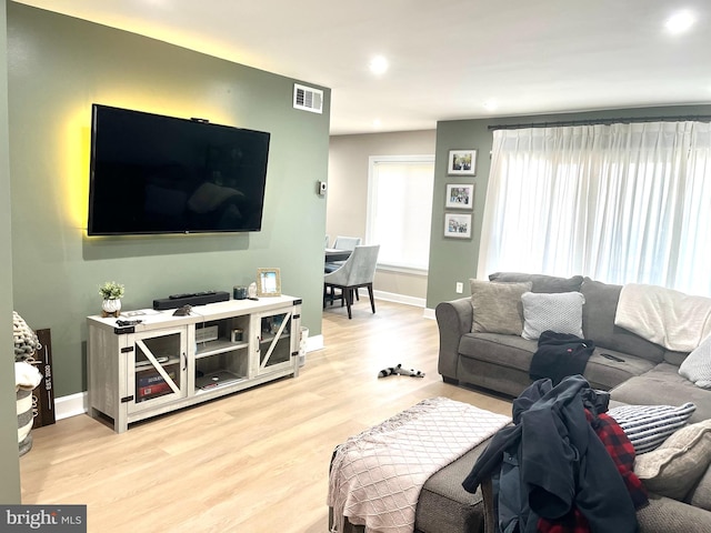 living area featuring baseboards, visible vents, wood finished floors, and recessed lighting