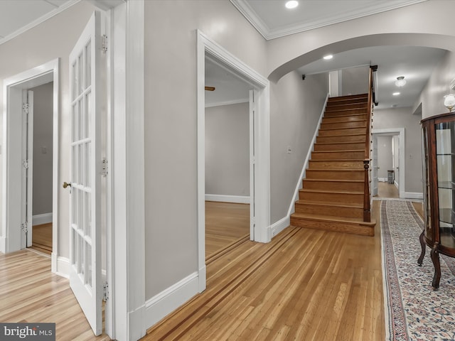 interior space with arched walkways, crown molding, recessed lighting, wood finished floors, and baseboards