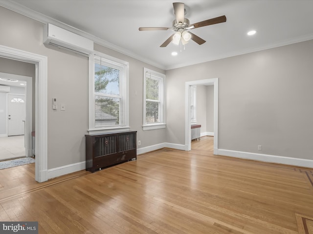 spare room with crown molding, recessed lighting, a wall mounted AC, light wood-style floors, and baseboards