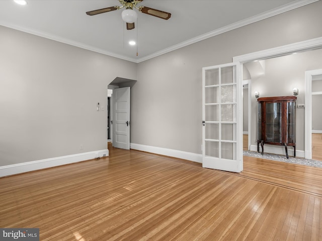 unfurnished room with light wood-type flooring, baseboards, a ceiling fan, and ornamental molding