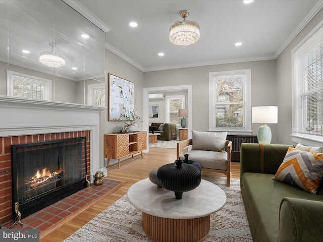 living room featuring recessed lighting, a fireplace, wood finished floors, and crown molding