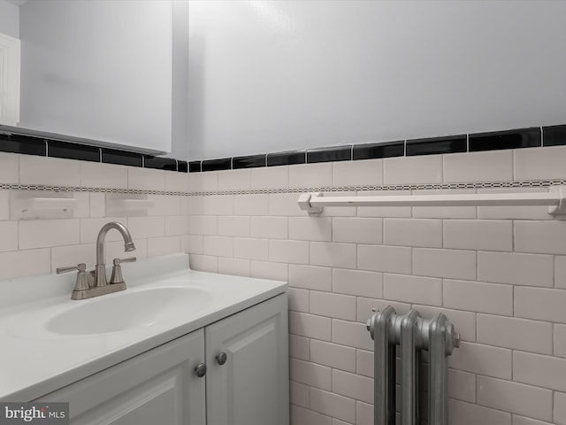 bathroom with tile walls, radiator, and vanity