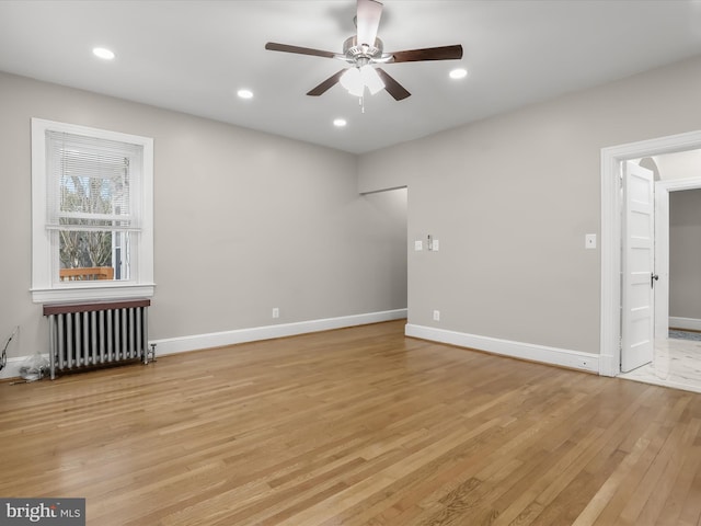 unfurnished room with radiator heating unit, recessed lighting, light wood-style flooring, and baseboards