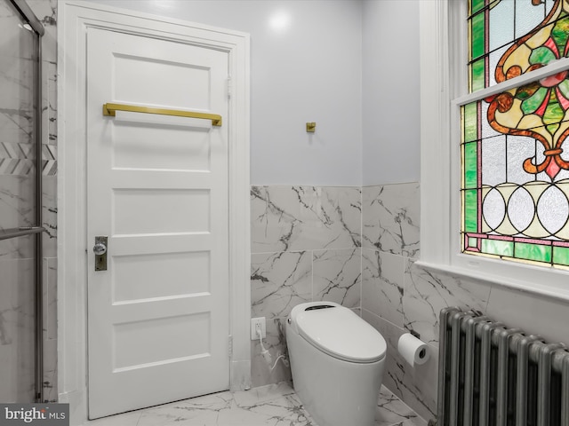 bathroom with toilet, tile walls, marble finish floor, wainscoting, and radiator heating unit