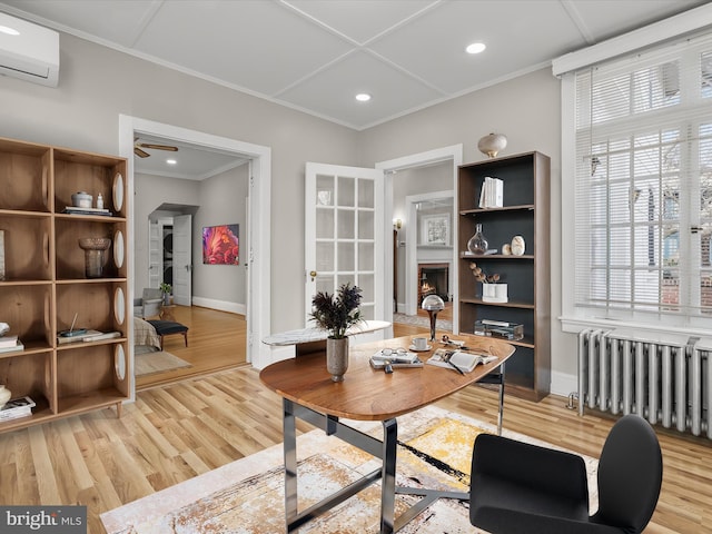 office space featuring a wall unit AC, crown molding, light wood finished floors, radiator heating unit, and a lit fireplace