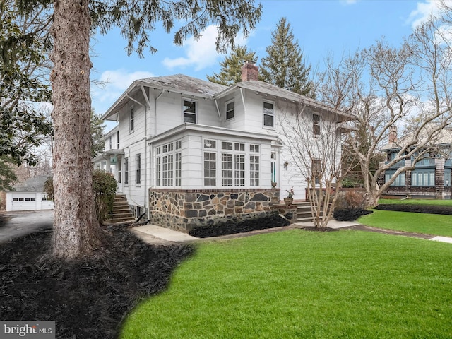 view of front of property featuring stone siding, a chimney, and a front lawn