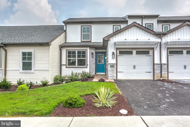 view of front of property with roof with shingles, aphalt driveway, and a front lawn