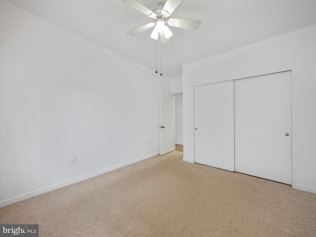 unfurnished bedroom with ceiling fan, carpet floors, a closet, and baseboards