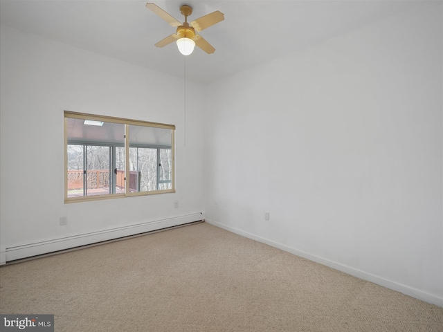 carpeted spare room featuring a baseboard heating unit, baseboards, and a ceiling fan