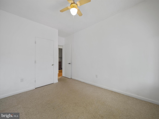 unfurnished bedroom featuring carpet, a ceiling fan, and baseboards