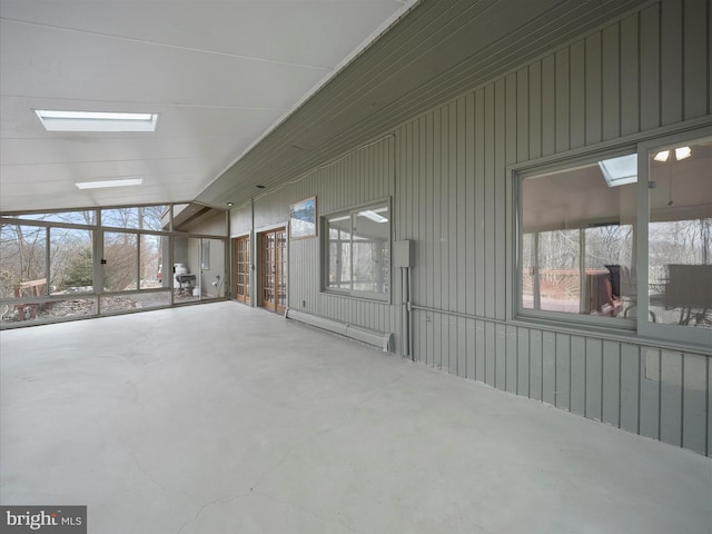 unfurnished room with concrete flooring, lofted ceiling, and baseboard heating