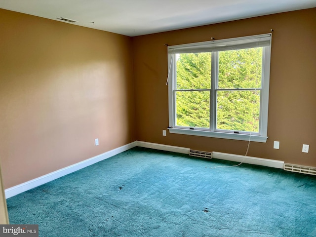 empty room with carpet floors, visible vents, and baseboards