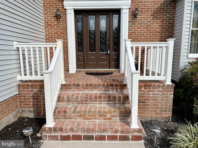 doorway to property featuring brick siding