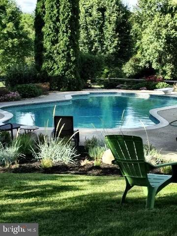 outdoor pool featuring a diving board and a yard