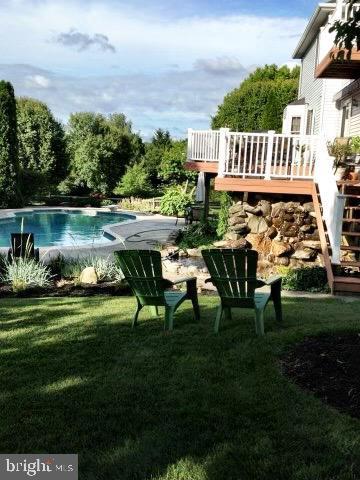 pool with a yard and a wooden deck