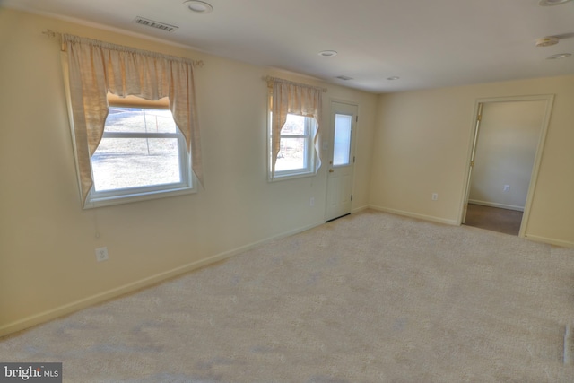 carpeted empty room featuring visible vents and baseboards