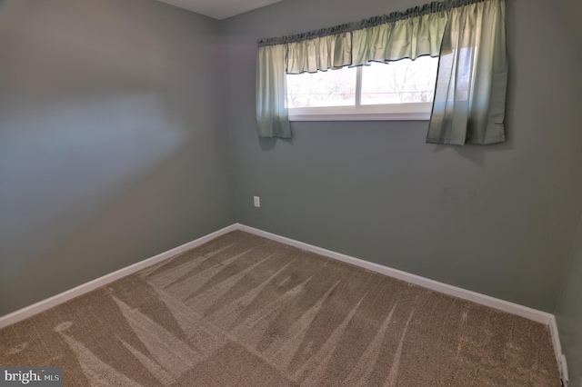 unfurnished room with carpet floors and baseboards