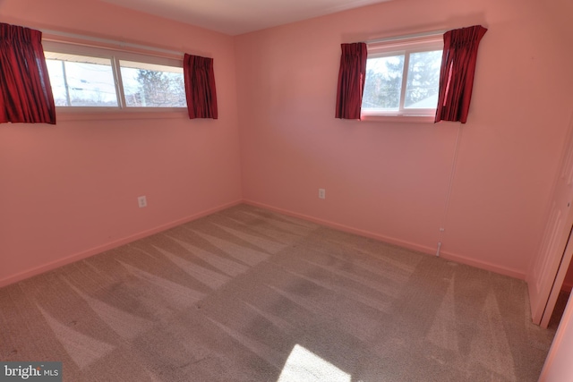 unfurnished room featuring carpet and baseboards