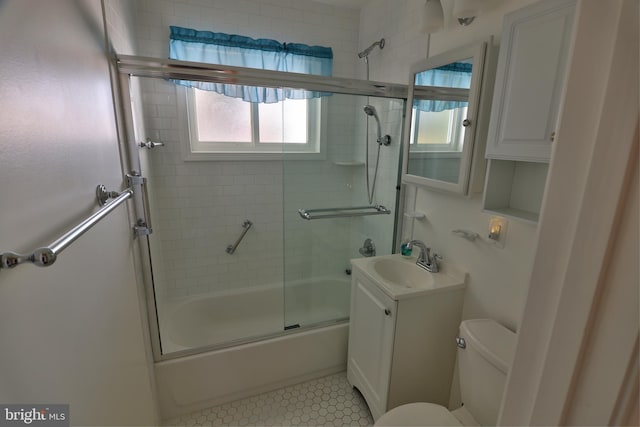 bathroom with toilet, combined bath / shower with glass door, and vanity