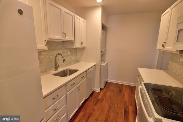 kitchen with dishwasher, stacked washer / dryer, freestanding refrigerator, a sink, and range with electric stovetop