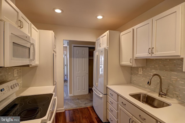 kitchen with white appliances, light countertops, a sink, and white cabinets