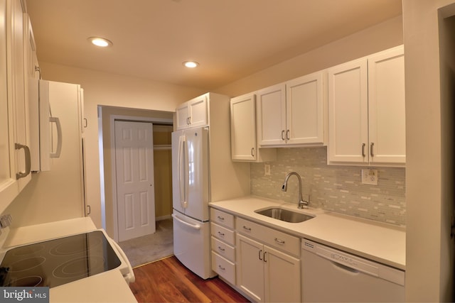 kitchen with recessed lighting, white appliances, a sink, white cabinetry, and decorative backsplash