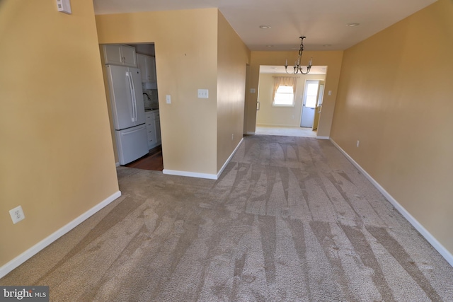 interior space featuring a chandelier, carpet, and baseboards