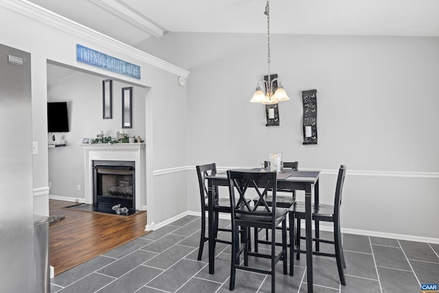 dining room with vaulted ceiling with beams, an inviting chandelier, a fireplace with flush hearth, and baseboards