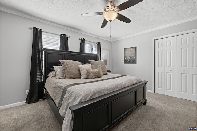 bedroom with a textured ceiling, a closet, carpet flooring, and baseboards