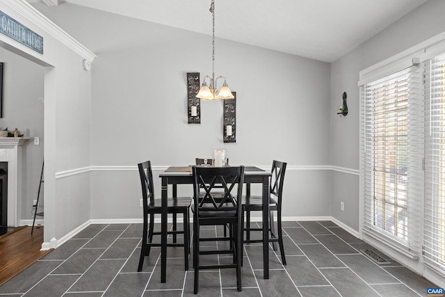 dining area featuring a glass covered fireplace, plenty of natural light, and dark tile patterned floors