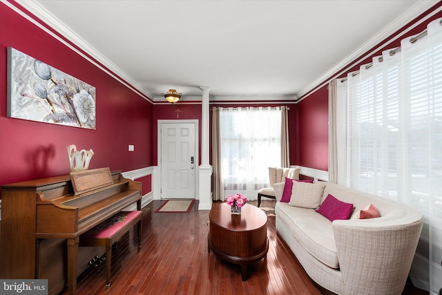 sitting room with ornate columns, crown molding, and wood finished floors