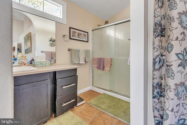 full bathroom featuring a stall shower, tile patterned flooring, and vanity