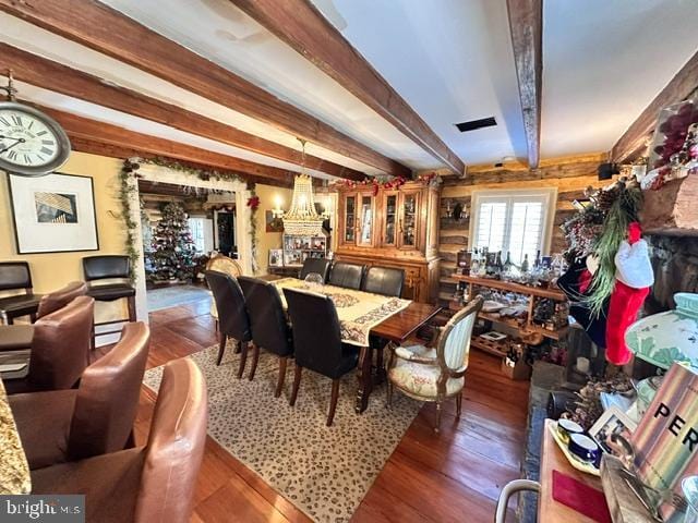 dining space with hardwood / wood-style flooring and beamed ceiling