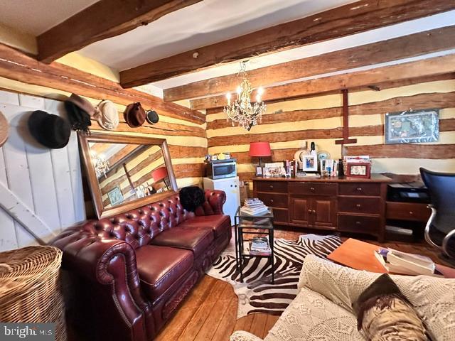 living room featuring a chandelier and beam ceiling