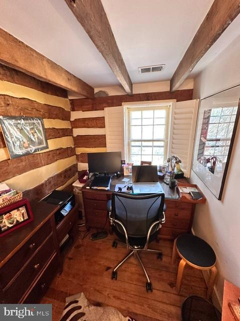 office featuring beamed ceiling, wood finished floors, and visible vents