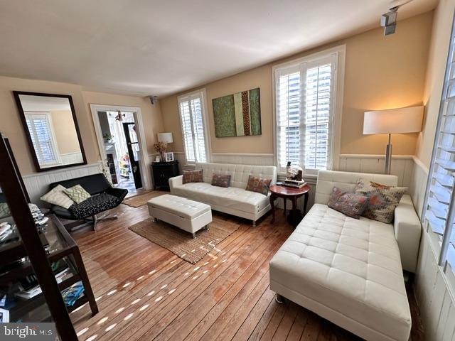 living room featuring a wainscoted wall and hardwood / wood-style floors