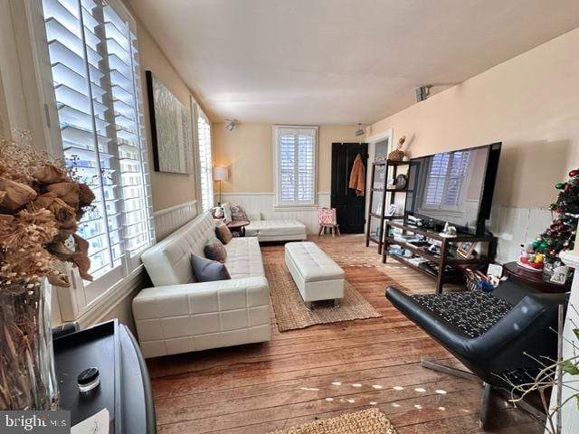 living area with wainscoting and wood finished floors