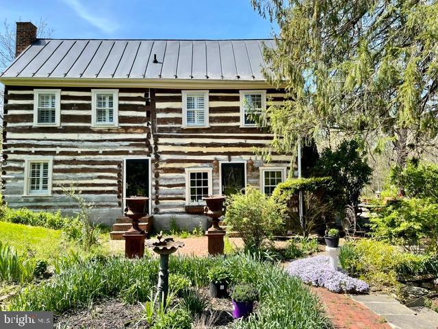 log-style house with a standing seam roof, log siding, and metal roof